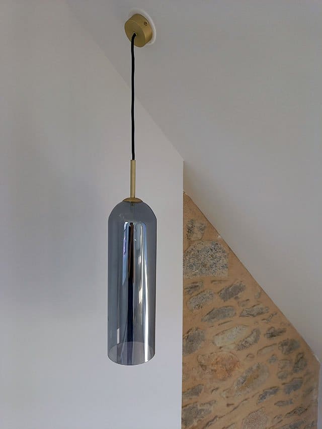 Suspension tube en verre fumé sous un plafond mansardé