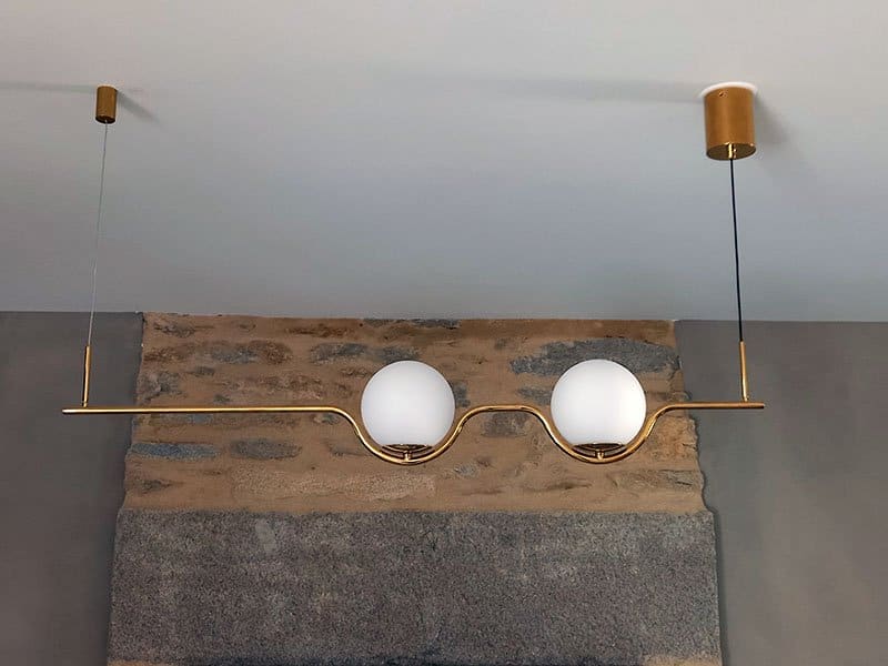 Suspension laiton à deux globes au-dessus d'une cheminée en pierre